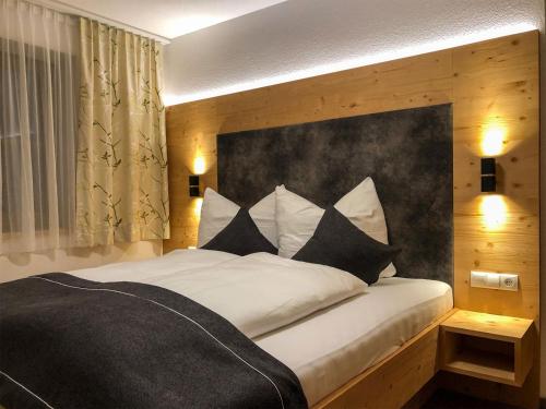 una camera da letto con un grande letto con cuscini bianchi e neri di Badererhof Christine Wechselberger a Stumm