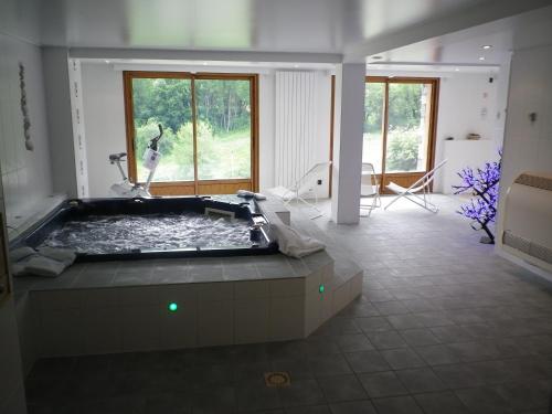 サン・ソルラン・ダルヴにあるChalet Beausoleil 4 étoiles - jacuzzi - au pied des pistes - domaine les sybellesの大きなバスルーム(窓のあるバスタブ付)