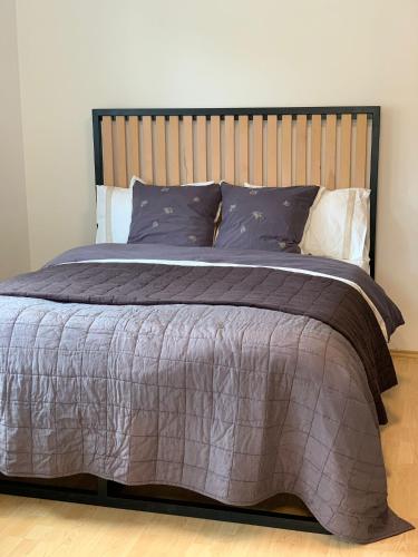 a bedroom with a large bed with a wooden headboard at LIPNO BEACH SIDE - RIVIERA APARTMENT in Lipno nad Vltavou