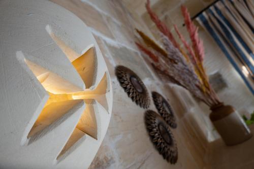 a white plate with a light on a wall at Centre Island Holiday Home with private pool and hot tub in Kerċem