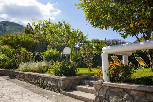 a garden with a white gazebo and flowers at Hotel Parco Delle Agavi in Ischia