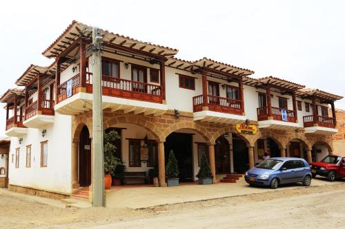 a small blue car parked in front of a building at Hospederia Villa de los Sáenz in Villa de Leyva