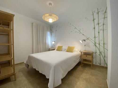 a bedroom with a white bed and a lamp at Vivienda vacacional sur de europa b 3 3 in La Restinga