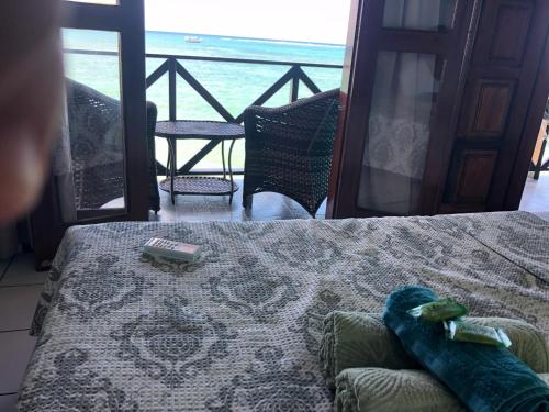 a bedroom with a bed and a view of the ocean at Pousada Tranquila in Morro de São Paulo