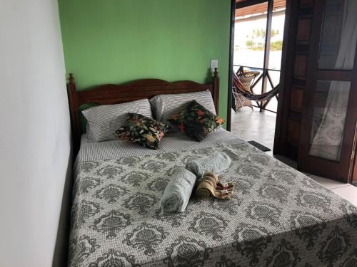 a bed with a blanket and pillows on it at Pousada Tranquila in Morro de São Paulo