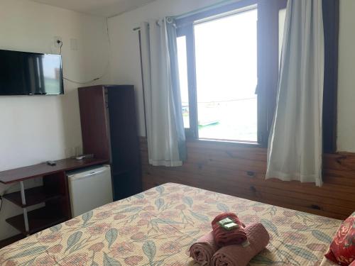 a bedroom with a bed with a stuffed animal on it at Pousada Tranquila in Morro de São Paulo