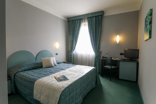 a hotel room with a bed and a desk at Hotel Vittoria in Sondrio