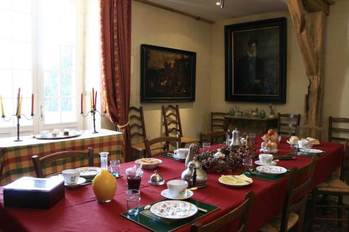 jadalnia z długim stołem z czerwoną tkaniną w obiekcie Le Moulin de Montrésor w mieście Montrésor
