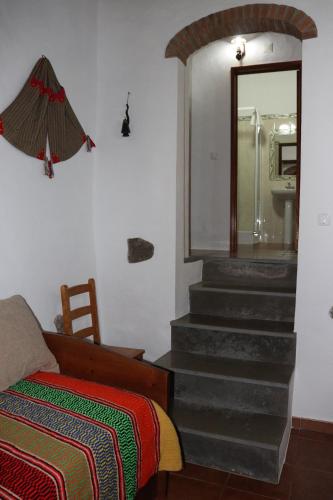 a room with a bed and stairs with a mirror at Casa do Celeiro - Monsaraz in Monsaraz