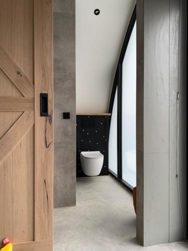 Un baño con inodoro blanco y ventana. en Penthouse Witsand Zeezicht, en Egmond aan Zee