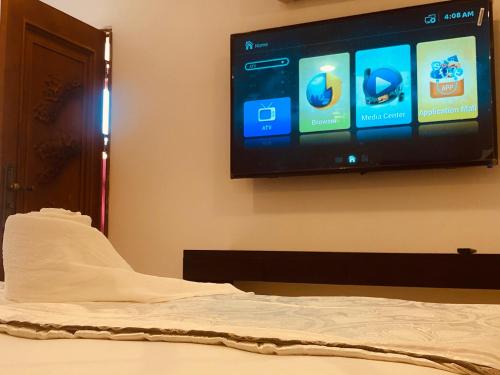 um quarto com uma cama e uma televisão na parede em Tiverton Homestay em Godagandeniya