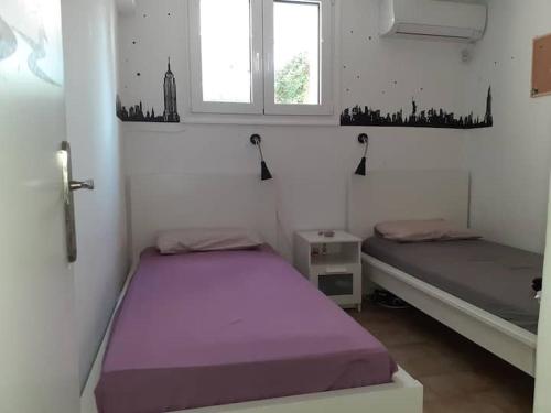 twee bedden in een kamer met twee ramen bij Breezy summer maisonette with exciting view! in Aghia Marina