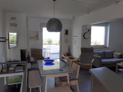 een woonkamer met een tafel en een bank bij Breezy summer maisonette with exciting view! in Aghia Marina
