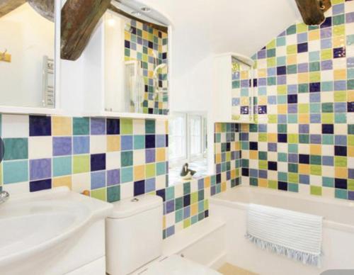 y baño con lavabo, aseo y bañera. en Beautiful Cottage in Llanfair with ocean views en Llanfair