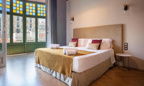 a bedroom with a large bed and a large window at You Stylish Paseo de Gracia Apartments in Barcelona