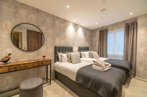 a bedroom with a large bed and a mirror at Entire 2 Bed - Free Parking - No. 15 - The Cosy Collection Ltd in York