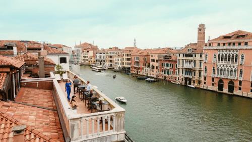 a group of people standing on a bridge over a river at Palazzo Barocci in Venice