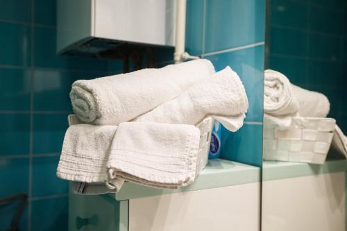 ザグレブにあるApartman Retroの浴室の棚に積み重ねられたタオル