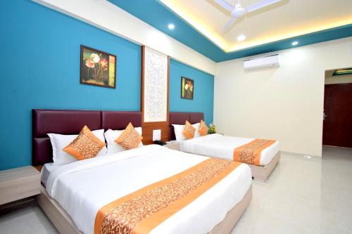 2 camas en una habitación con paredes azules en The Sky Imperial- Hotel Gopal Darshan, en Nathdwara