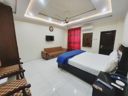 a bedroom with a bed and a couch in a room at Hotel White Pearl in Lahore