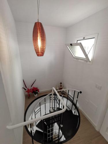 a spiral staircase in a room with a pendant light at Villa Megila in Caleta De Fuste