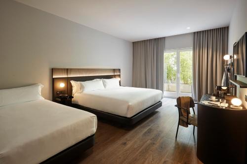 Habitación de hotel con 2 camas y ventana en Chic & Basic Gravity en Oporto