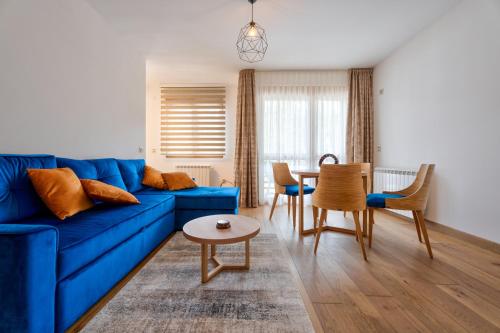 a living room with a blue couch and a table at V&Dj in Zlatibor