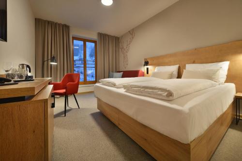 a hotel room with a large bed and a desk at Hotel Element in Lipno nad Vltavou
