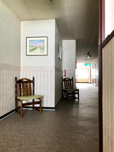 a hallway with two chairs and a bench on a wall at Hotel El Mayo in Hakuba