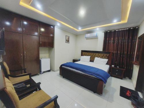 a bedroom with a bed and a chair in it at Hotel White Pearl in Lahore