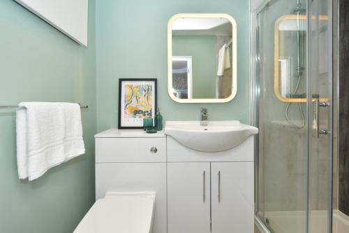 a bathroom with a sink and a mirror at Antrobus Deluxe Apartments by YourStays in Congleton