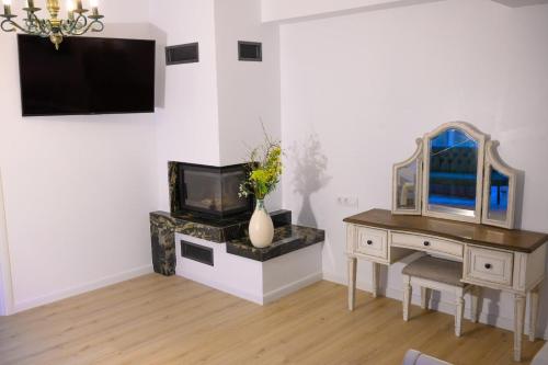 a room with a desk and a television and a vase with flowers at 7Soapte in Braşov