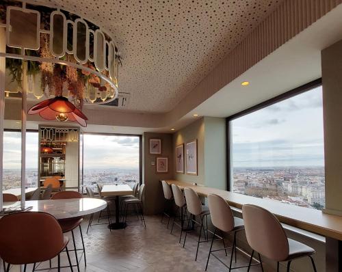 a restaurant with tables and chairs and large windows at Riu Plaza España in Madrid