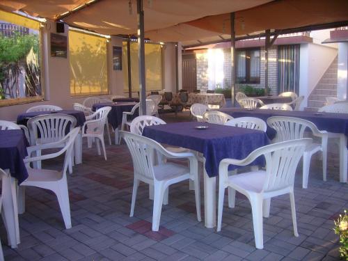 un restaurante con mesas, sillas blancas y mesas azules en Villa Nikola Ohrid, en Ohrid