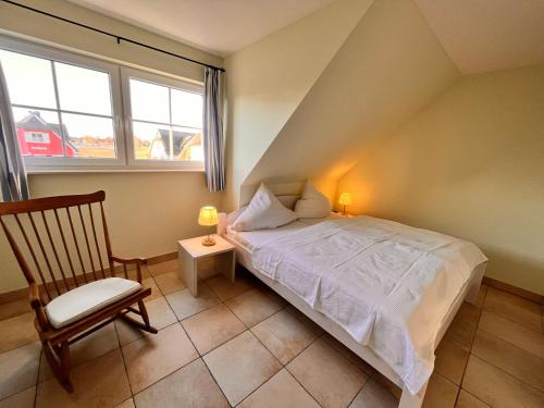 布雷格的住宿－Ferienhaus Wellenläufer，卧室配有床、椅子和窗户。