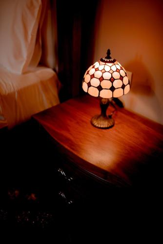 a small lamp on a wooden table in a bedroom at Melies Hotel in Kokkinórrakhi