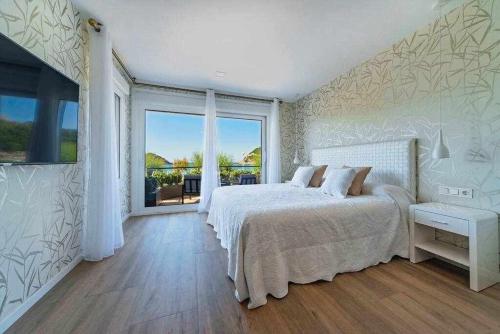 サン・セバスティアンにあるLa Concha Beach Deluxeの白いベッドルーム(ベッド1台、大きな窓付)