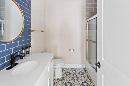 a bathroom with a sink and a toilet and a mirror at Renovated Beach Block 7BR North Beach Atlantic City - Steps to Beach & Casino in Atlantic City