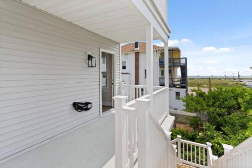 a porch of a white house with a cat sitting on it at Renovated Beach Block 7BR North Beach Atlantic City - Steps to Beach & Casino in Atlantic City