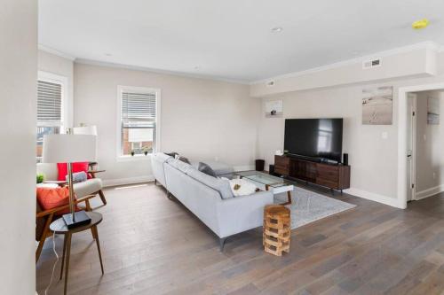 a living room with a couch and a flat screen tv at Renovated Beach Block 7BR North Beach Atlantic City - Steps to Beach & Casino in Atlantic City