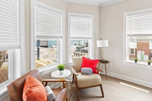 a living room with a couch and chairs and windows at Renovated Beach Block 7BR North Beach Atlantic City - Steps to Beach & Casino in Atlantic City