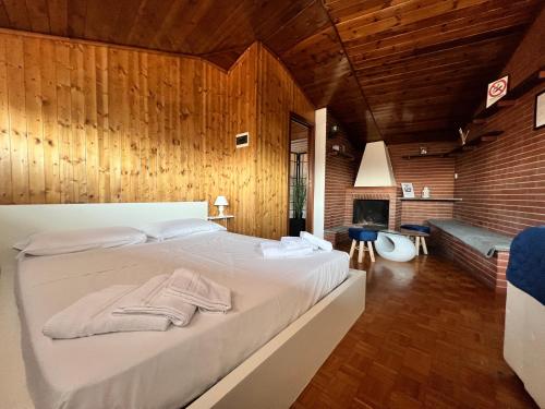 a bedroom with a large white bed with wooden walls at B&B Elegance in Bologna