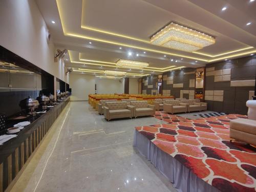 a banquet hall with couches and tables in a room at Hotel Ganpati Palace in Mathura