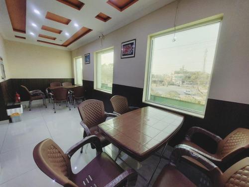 a waiting room with a table and chairs at Hotel White Pearl in Lahore