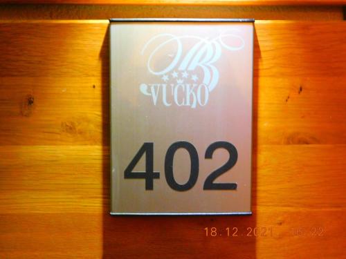 a sign on a wooden wall with the number at Aparthotel Vučko Apartment Lora in Jahorina