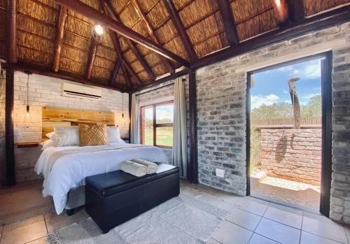a bedroom with a bed and a large window at Charihandra Game Lodge in Addo