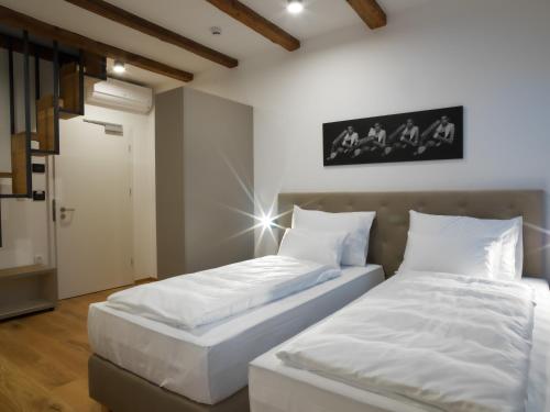 two beds sitting next to each other in a room at Hotel Belmur in Murska Sobota