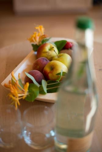 a plate of fruit on a table next to a bottle at Hotel-Gasthof Mauthäusl in Weißbach