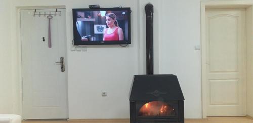 a television on a wall with a fireplace with a tv at Apartmani Grza in Paraćin