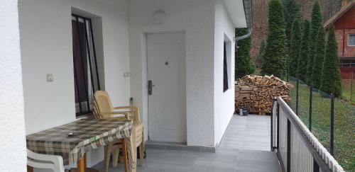 a porch with a table and chairs on a balcony at Apartmani Grza in Paraćin